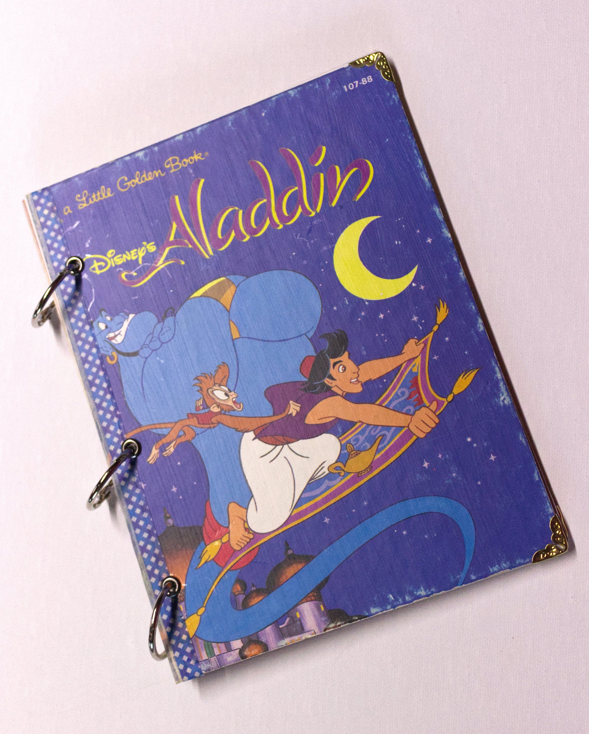 Upcycled children’s book journal made from Aladdin hardcover, featuring three characters from Aladdin on the front cover.
