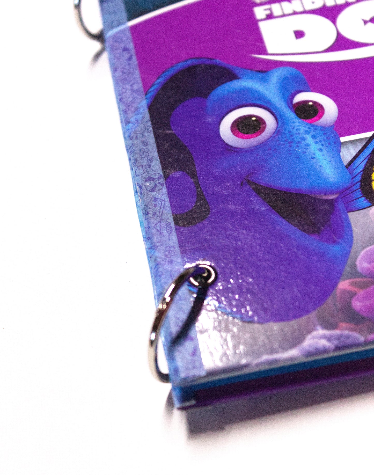 Metal ring binding on an upcycled The Finding Dory book journal with reinforced corners.
