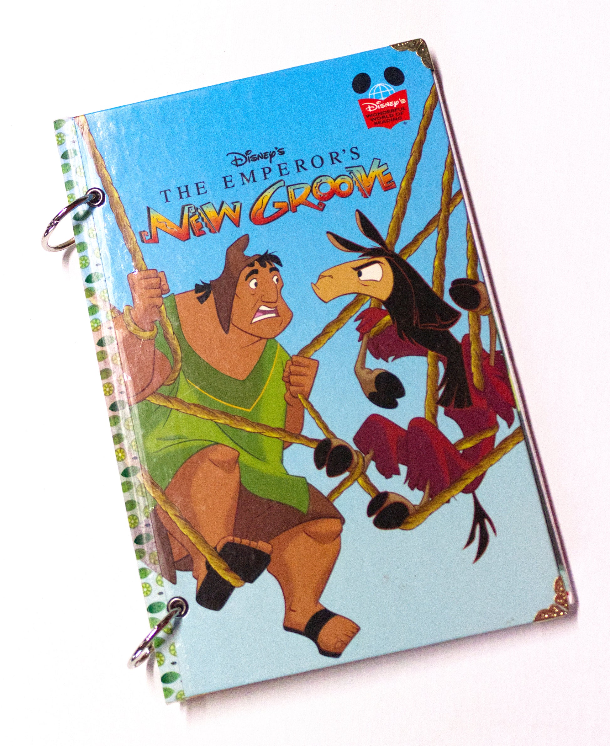 Upcycled children’s book journal made from The Emperor’s New Groove hardcover, featuring Pacha and Kuzco on the front cover.