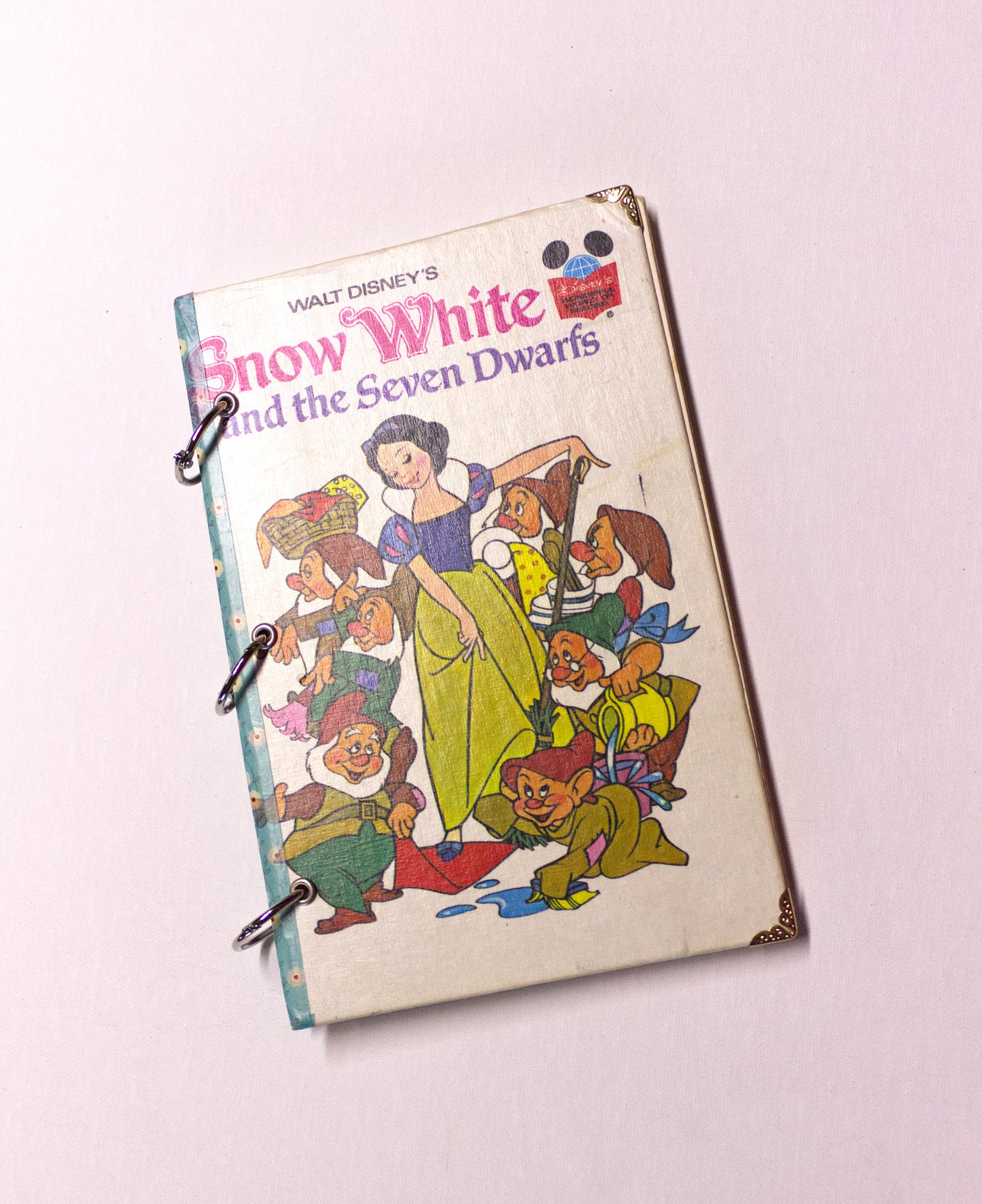 Upcycled children’s book journal made from Snow White hardcover, featuring a princess and seven dwarfs on the front cover.