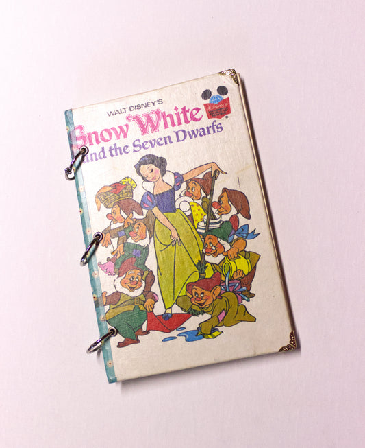 Upcycled children’s book journal made from Snow White hardcover, featuring a princess and seven dwarfs on the front cover.